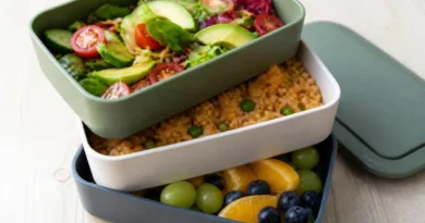 Mehrstöckig, modular, smart: außergewöhnliche Lunchboxen Mehrstöckige Lunchbox mit drei Modulen, gefüllt mit Salat, Reisgericht und Obst
