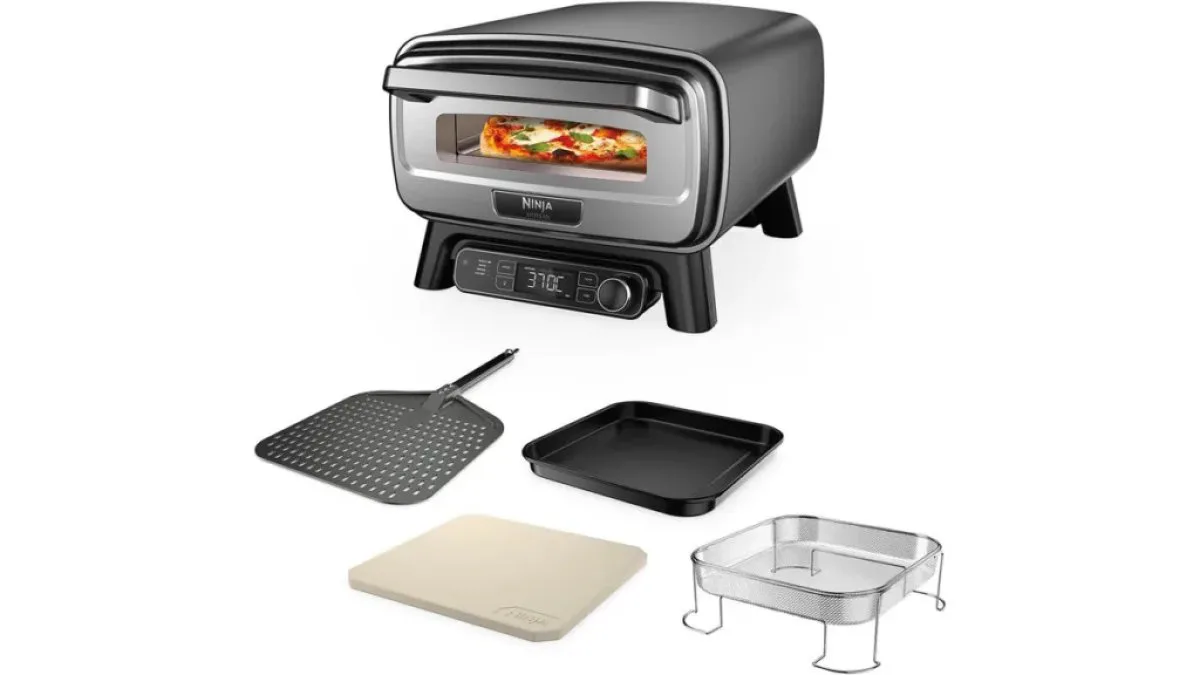 Ninja Artisan Outdoor-Pizzaofen mit Pizzaschieber, Backform und Pizzastein auf Holzuntergrund
